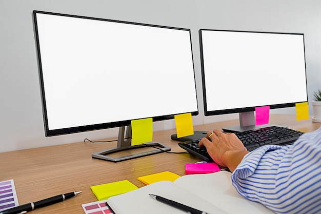 Photo main coupée d'un homme d'affaires utilisant des ordinateurs blancs à son bureau au bureau