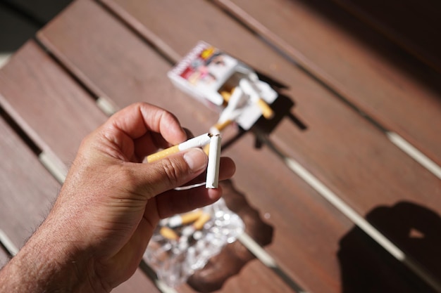 Photo main coupée d'un homme sur des cigarettes sur la table