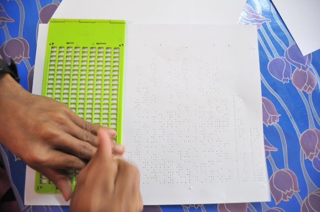 Photo la main coupée d'un homme étudiant le braille sur la table