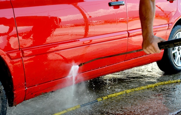 Main coupée d'un homme lavant une voiture