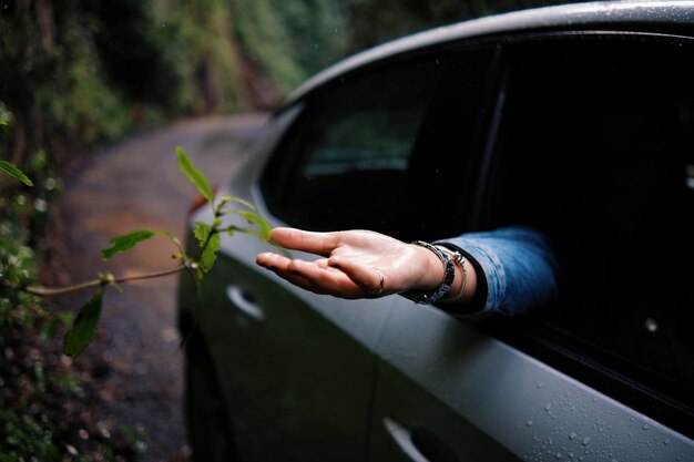 Photo main coupée d'un homme tenant une voiture