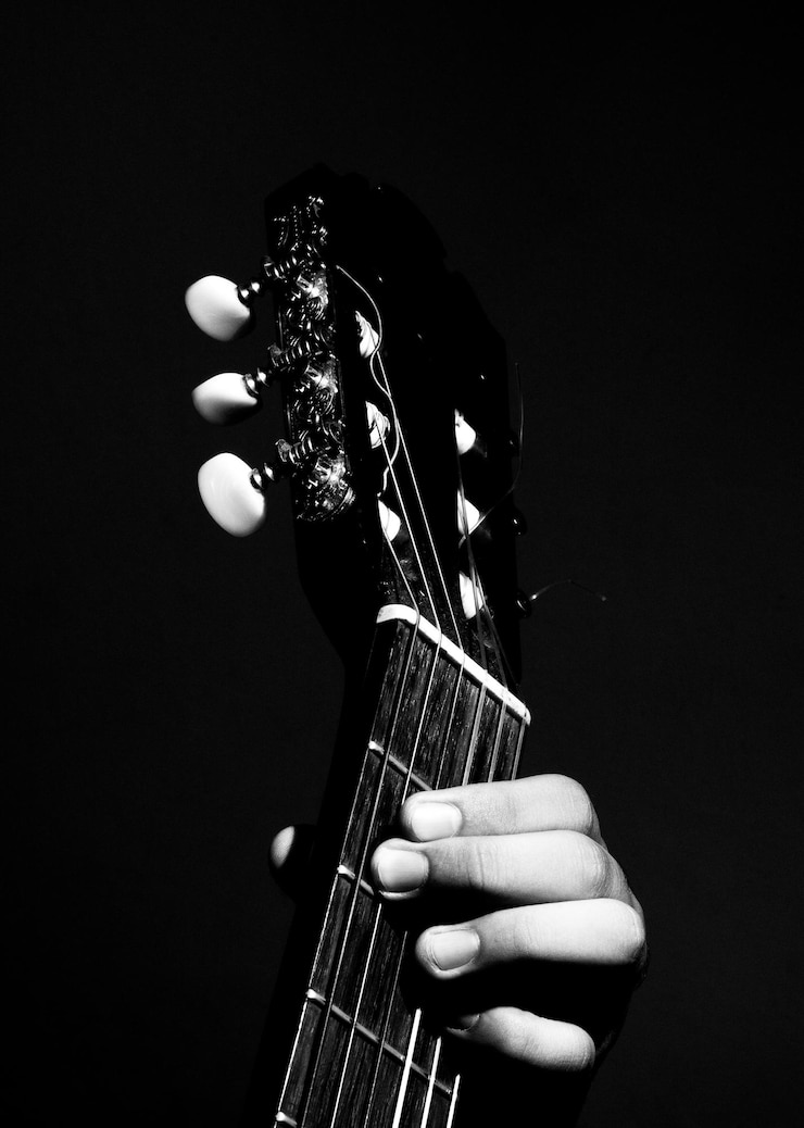 Photo une main coupée jouant d'un instrument à cordes sur un fond noir