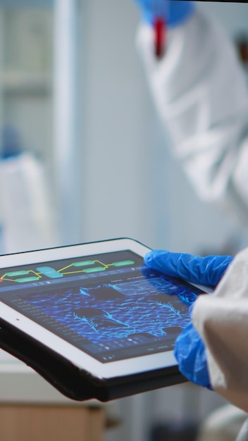 Photo main coupée d'un médecin tenant une tablette numérique en laboratoire