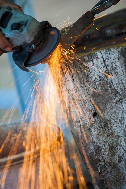 Photo main coupée d'un ouvrier coupant une tige de fer dans l'industrie