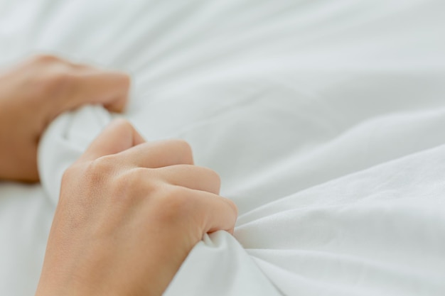 Main coupée d'une personne allongée sur le lit