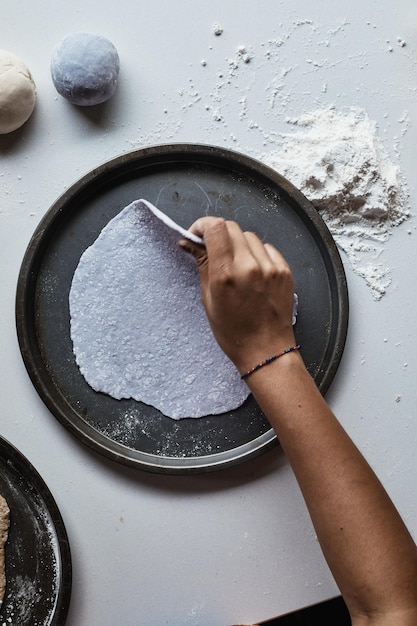 Photo main coupée d'une personne préparant de la nourriture sur la table