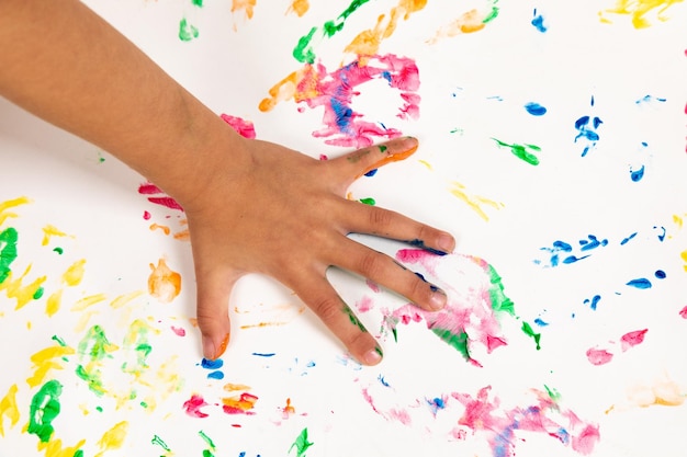 Photo la main coupée d'une personne touchant une table colorée et en désordre