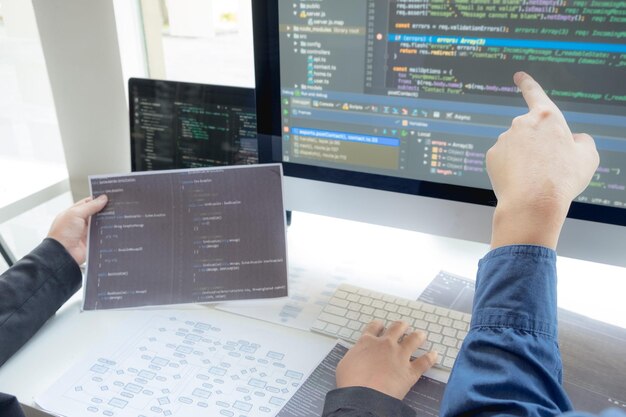 La main coupée d'un programmeur d'ordinateur en train de réfléchir au bureau.