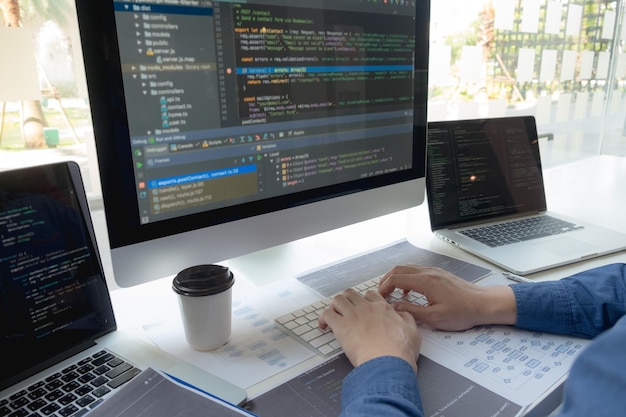 La main coupée d'un programmeur d'ordinateur en train de réfléchir au bureau.