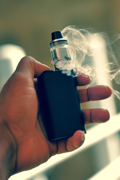 Main coupée tenant une cigarette électronique