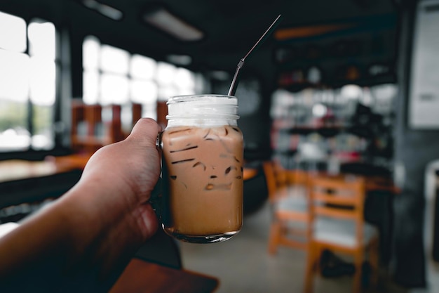 Main coupée tenant du café dans un café