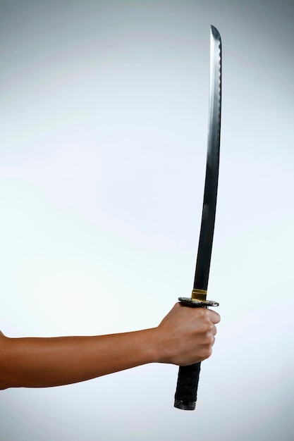 Photo main coupée tenant une épée sur fond blanc
