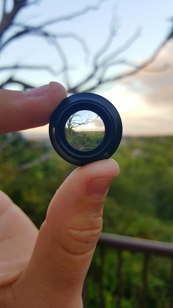 Photo main coupée tenant un objet contre le ciel