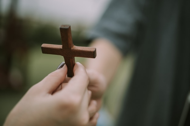 Main avec croix. Concept d'espoir, de foi, de christianisme, de religion, d'église en ligne.