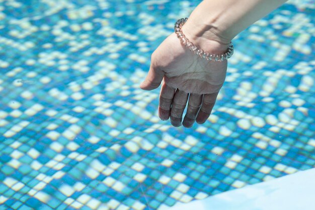 Main dans l'eau de la piscine