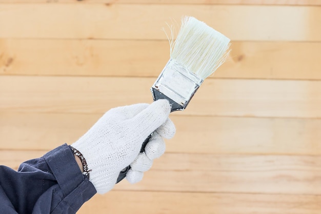 La main dans un gant de coton tenant des peintures à pinceau