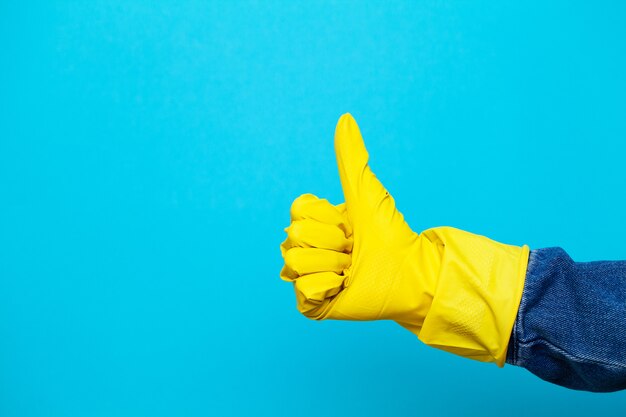 Photo la main dans un gant jaune pour le nettoyage