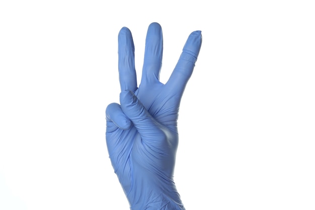 Main dans un gant médical montrer trois doigts isolés sur fond blanc isolé