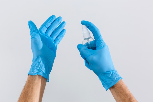 main dans des gants chirurgicaux en caoutchouc tenant un désinfectant antiseptique pour les mains sur fond. désinfectants à l'alcool ou gel pour la protection contre le virus corona pour l'hygiène des mains. Liquide antibactérien contre covid-19