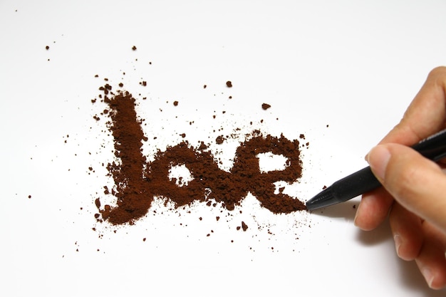 Une main dessinant un nom avec un stylo noir qui dit Joe dessus