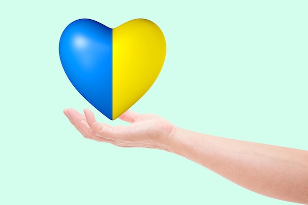 Main avec le drapeau national de couleur coeur de l'Ukraine