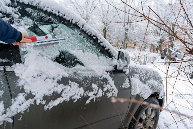 La main du conducteur crée la voiture de la neige le matin avant le voyage