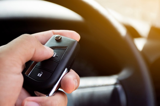 La main du conducteur est appuyée sur la télécommande du véhicule sans clé.