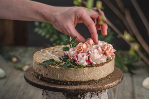 La Main Du Décorateur Décorant Le Gâteau Mousse Avec Des Fleurs Roses De Tendresse