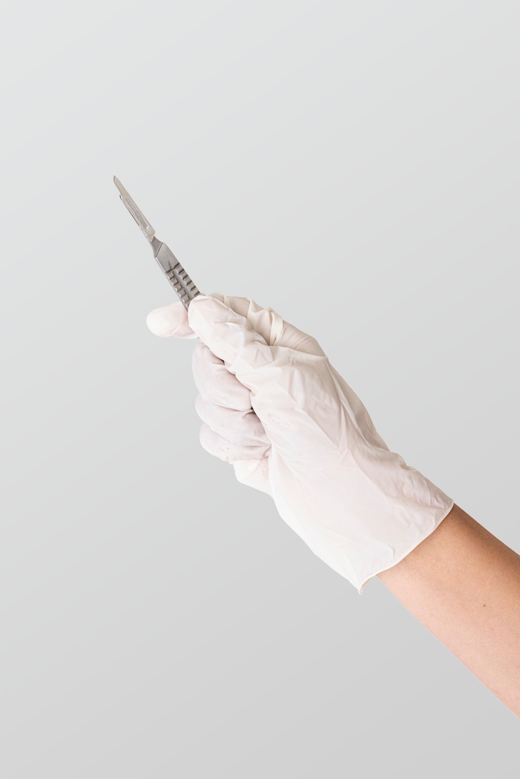 Photo la main du docteur dans un gant blanc tenant un scalpel