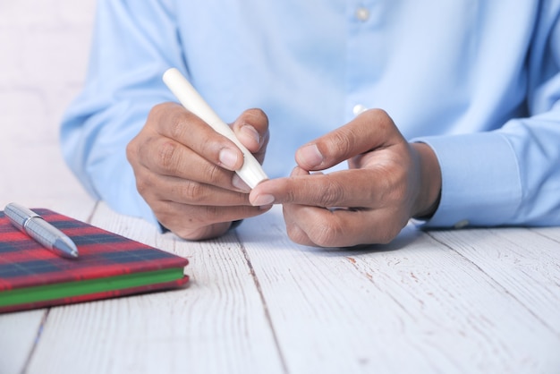 La main du jeune homme mesure le niveau de glucose à la maison.