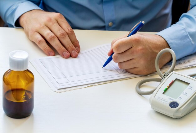 La main du médecin écrit à la table avec un tonomètre