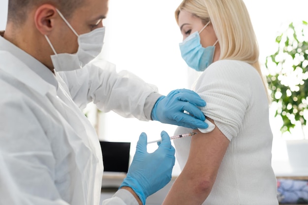 main du personnel médical injectant le vaccin contre le coronavirus covid-19 dans une seringue de vaccin pour armer le muscle d'un homme caucasien pour la vaccination contre le coronavirus covid-19, vaccination contre le coronavirus covid-19, mise au point sélective