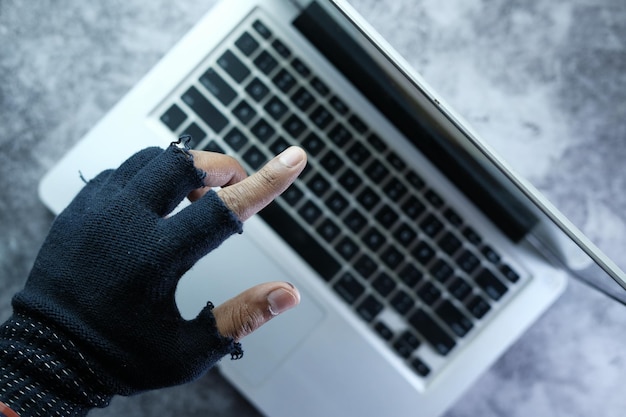 La main du pirate pointe le doigt sur l'écran de l'ordinateur portable
