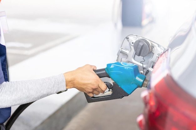 La main du ravitailleur fait le plein de carburant dans la voiture de la station-service.