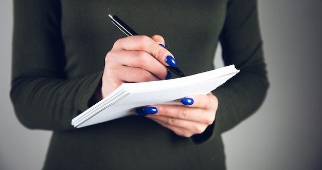 La main écrit avec un stylo dans un cahier