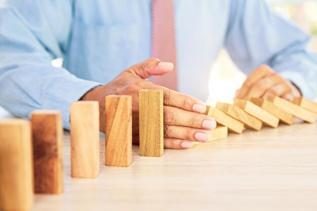 Photo la main empêche le bloc de bois de ne pas tomber domino