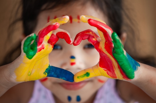 Main de l&#39;enfant avec aquarelle coloré peint faire la forme de coeur avec amour