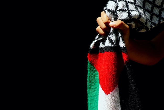 Main D'enfant Asiatique Avec Foulard Drapeau Palestine, Sur Fond Sombre.