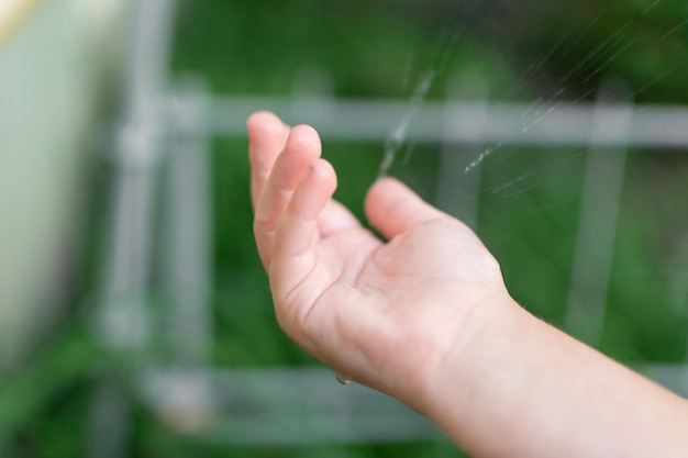 La main d'un enfant attrape une goutte d'eau