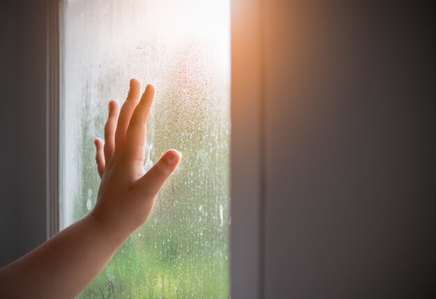 Main enfant avec brouillard sur la fenêtre.