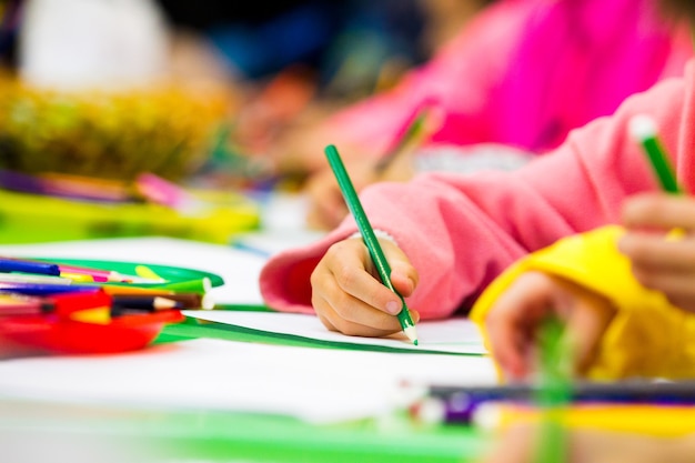 Main d'un enfant dessinant un crayon sur papier, une partie du corps