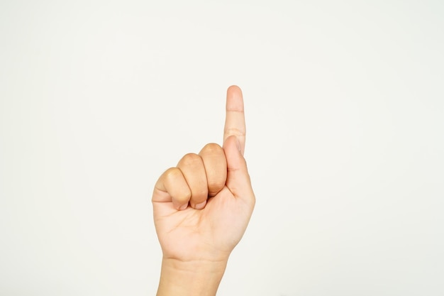 La main de l'enfant avec le doigt pointé vers le haut pointant vers quelque chose sur un fond blanc la main fermée