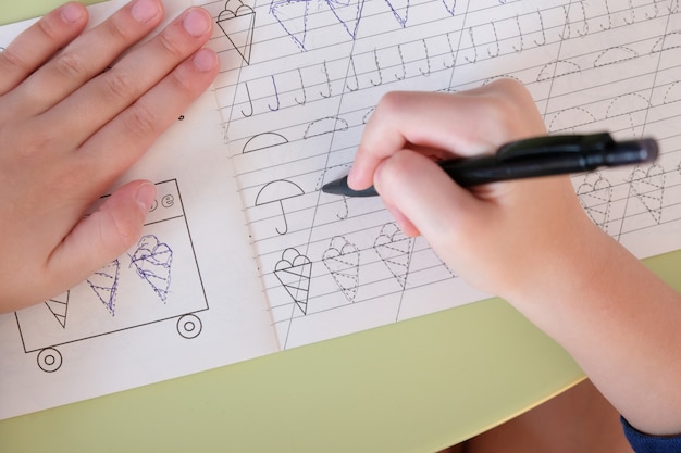 main d'enfant écrit la recette à la table