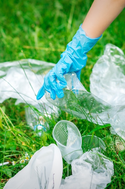 La main de l'enfant nettoie le parc des débris en plastique