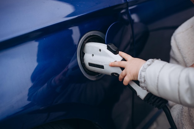 La main des enfants charge la voiture électrique