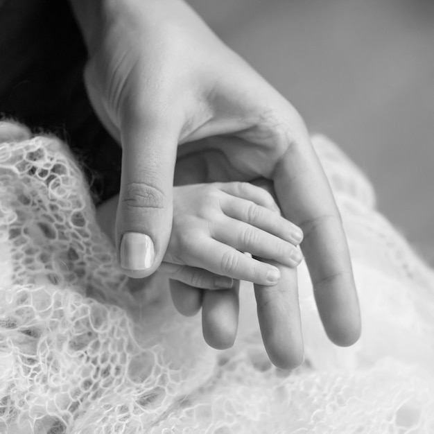 La main des enfants nouveau-nés dans la main de la mère maman et son enfant concept de famille heureuse belle image conceptuelle de la maternité