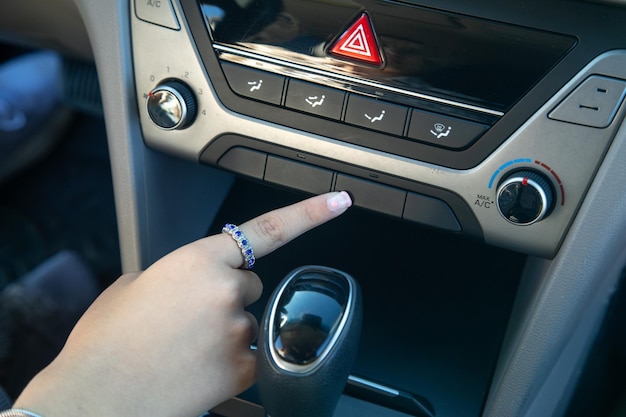 Main féminine appuyez sur le bouton de la voiture