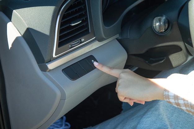 Main féminine appuyez sur le bouton de la voiture