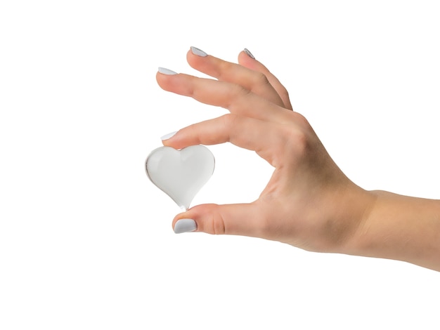 Main féminine avec coeur de verre isolé