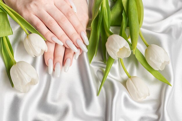 Main féminine avec conception d'ongles à ressort